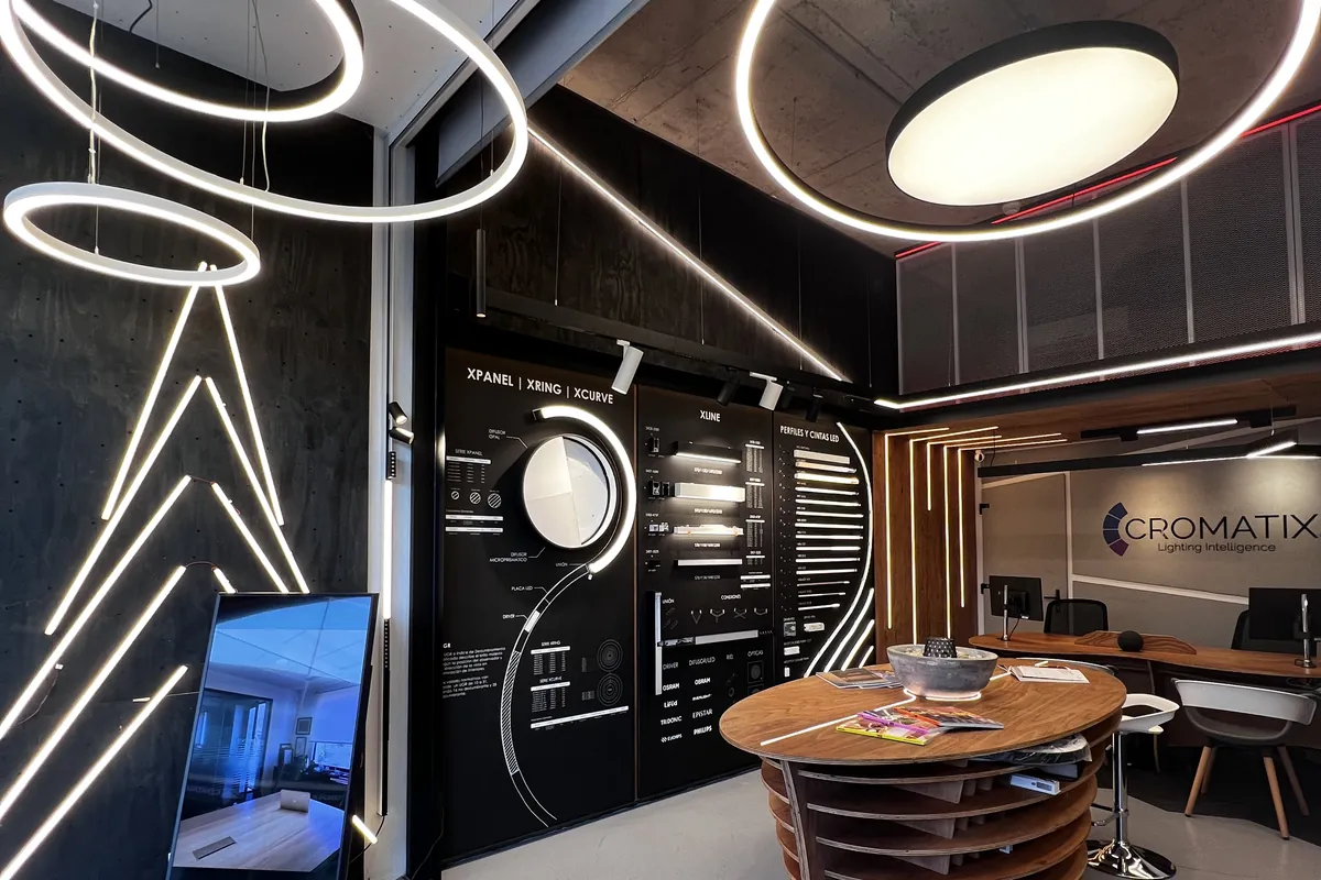 Showroom de Luminova y CROMATIX en Las Condes Design: anillos XRING encendidos, muro de producto y mesa de atención